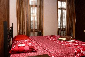 第比利斯KIEV ROAD APARTMENT的一间卧室配有一张带红色床单和枕头的床。
