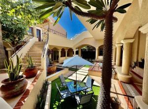 圣何塞德尔卡沃Marisol Hotel Boutique的棕榈树、椅子和遮阳伞的房子