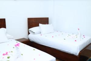 卢克索Jasmine Nile apartments的一间卧室配有两张带鲜花的床单