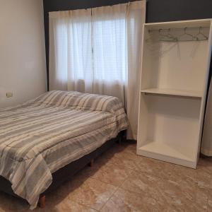 雷孔基斯塔Departamento Reconquista - Perla del Norte的一间卧室设有一张床和一个窗口