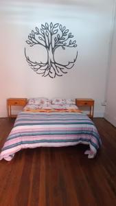 科洛尼亚-德尔萨克拉门托Posada the secret的卧室配有一张床铺,墙上挂着一棵树