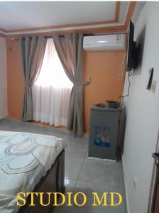 科纳克里Résidence Diakhaby的客房设有床、窗户和电视。