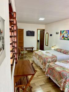 弗雷谢拉斯Pousada São Pedro的酒店客房设有两张床和一张桌子。