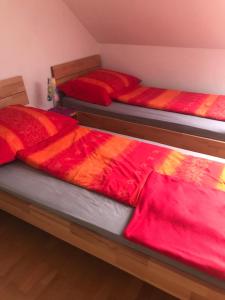 Oberwölbling维米埃特瑞尔酒店的红色和橙色毯子的客房内的两张床
