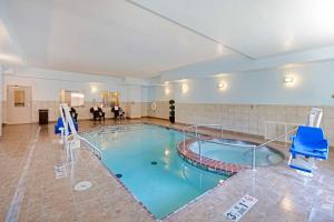 Guymon盖蒙贝斯特韦斯特PLUS酒店的大楼内带蓝色椅子的大型游泳池