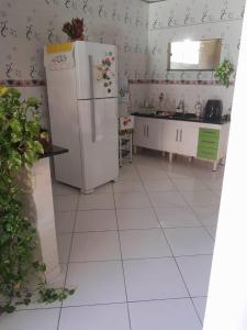 塞古罗港Casa Jardim的厨房铺有白色地板,配有冰箱。