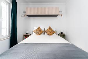 塞图巴尔Pátio da Baixa的卧室配有一张带两个枕头的大白色床