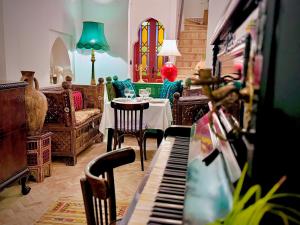 丹吉尔Riad Al-Qurtubi的客厅配有桌子和钢琴
