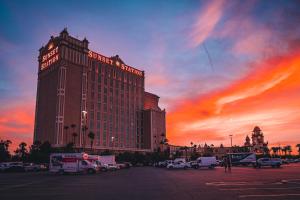 拉斯维加斯Sunset Station Hotel & Casino的一座大型酒店建筑,背景是日落