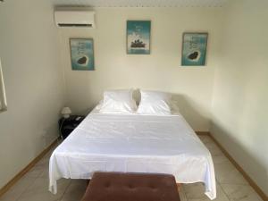 TaravaoTAHITI - Bungalow Toah Piti的卧室配有白色的床和棕色凳子