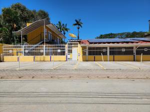 乌巴图巴Encantos do Lázaro的一座黄色的建筑,前面有一个停车位