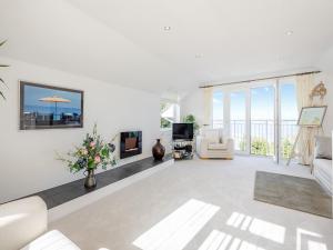 布里克瑟姆Heath Lodge的客厅配有白色家具,享有海景。