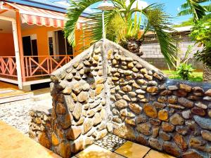 帕皮提TAHITI - Lihei Pool House的房屋前的石墙