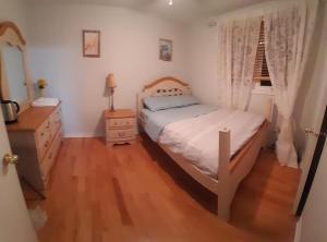 米西索加Cozy Place-Laid Back的卧室配有白色的床,铺有木地板