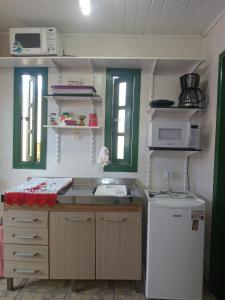 特拉曼达伊Kitnet da Elô的一间带水槽和冰箱的小厨房