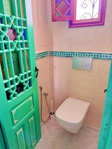 丹吉尔Hostel Al-Qurtubi的一间带卫生间和绿门的浴室
