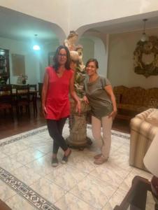 利马Habitación en Primer Piso con baño privado的两个女人站在一个房间里雕像旁边