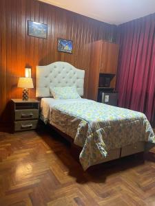 利马Habitación en Primer Piso con baño privado的一间卧室设有一张床和木墙