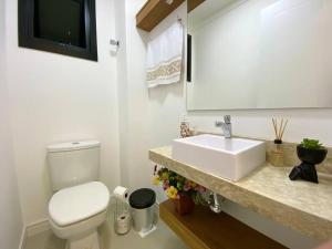 托雷斯Apto central e próximo à praia的浴室配有白色卫生间和盥洗盆。