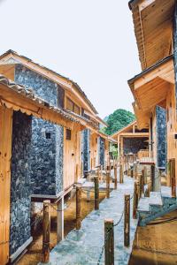Làng CacChien's Lodge Du Gia的中间有一排木结构建筑,中间有人行道