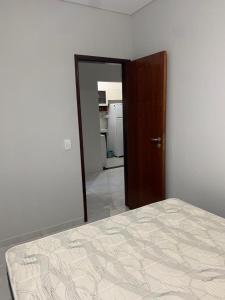 乌巴图巴Apartamento Maranduba的一间卧室配有一张床,一扇门通往厨房