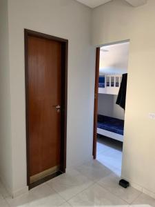 乌巴图巴Apartamento Maranduba的走廊设有木门和一间卧室