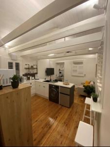 阿米代尔The Stables的一间铺有木地板的大厨房,拥有白色的墙壁和木地板。