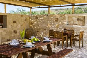 ChavriátaVilla Ydria的一个带桌椅和石墙的庭院