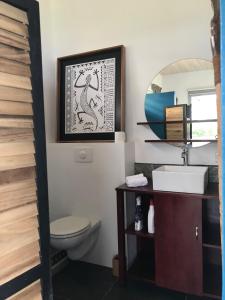 乌图罗阿La Suite Vue Lagon的一间带卫生间、水槽和镜子的浴室