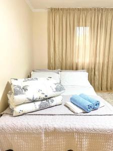 阿拉木图Town House, metro Raiymbek的一张带枕头和毛巾的白色床