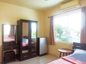 奈扬海滩Nu Phuket Airport Resident 1的一间卧室配有梳妆台、镜子和窗户。