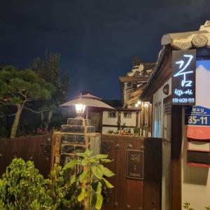 全州市好梦韩屋旅馆的夜间在建筑物前的标志