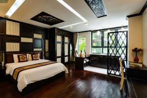 河内Wild Lotus Hotel Apartment 2的一间卧室配有一张床、一张书桌和一个窗户。