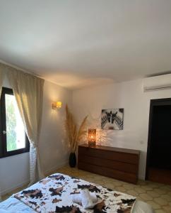 森图里Villa Marie Cap Corse sentier douaniers的一间卧室配有一张床、一个梳妆台和一扇窗户。