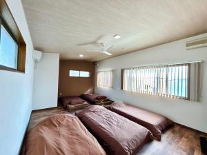 尾道市Beach Villa Tachibana的一间卧室设有两张床和窗户。
