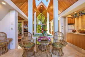 HueloLavish Cliff House with Ocean Views in Haiku, Maui jungle的一间设有玻璃桌和椅子的用餐室
