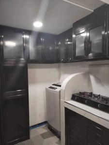 Mini Home Traveller’s Inn的厨房配有黑色橱柜和炉灶烤箱。
