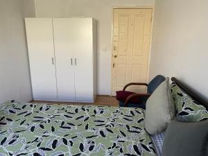 珀斯Double room share bathroom and kitchen的一间卧室配有一张床和一个衣柜及一扇门