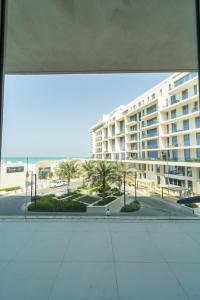 阿布扎比Luxury, 3 bedrooms, Saadiyat Island, spacious, beach & pool, restaurants, gym的从一个大建筑的窗户上可欣赏到风景
