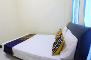 丹戎OYO Life 93157 Kos Kaloka的一间卧室配有一张带两个枕头的床