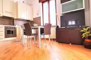 维罗纳Luxury Verona Apartment City Centre的厨房配有桌椅和平面电视。