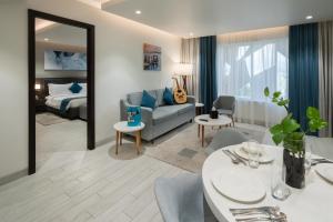 马斯喀特Citadines Al Ghubrah Muscat的带沙发、床和桌子的客厅