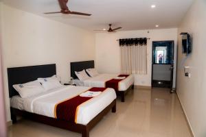 蒂鲁帕蒂Hotel Sitar Grand的一间卧室配有两张床和吊扇