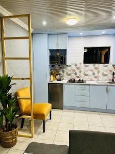 塞昆达Modern studio apartments的厨房配有蓝色橱柜和黄色椅子