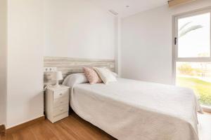 奥利瓦Orilla del mar的白色的卧室设有床和窗户