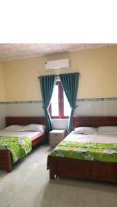 美奈San Vuon Guesthouse的一间卧室设有两张床和窗户。