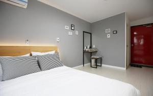 济州市MO Guesthouse的卧室配有一张白色大床和一张书桌