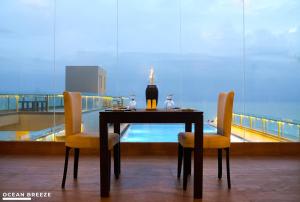 尼甘布Ocean Breeze by DOXA的一张桌子,上面有两把椅子和一个花瓶