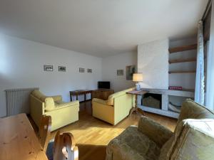 平佐洛Appartamenti Residenza Alpina的客厅配有黄色家具和壁炉