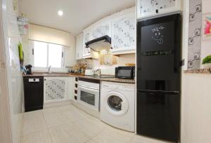 卡斯特利翁-德拉普拉纳Bonito piso en MarinaDor的厨房配有白色橱柜、洗衣机和烘干机